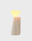 Decorative lamp with a beige base and glowing top on a light gray background