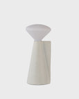 Modern table lamp with a white shade and light stone colored base on a light gray background