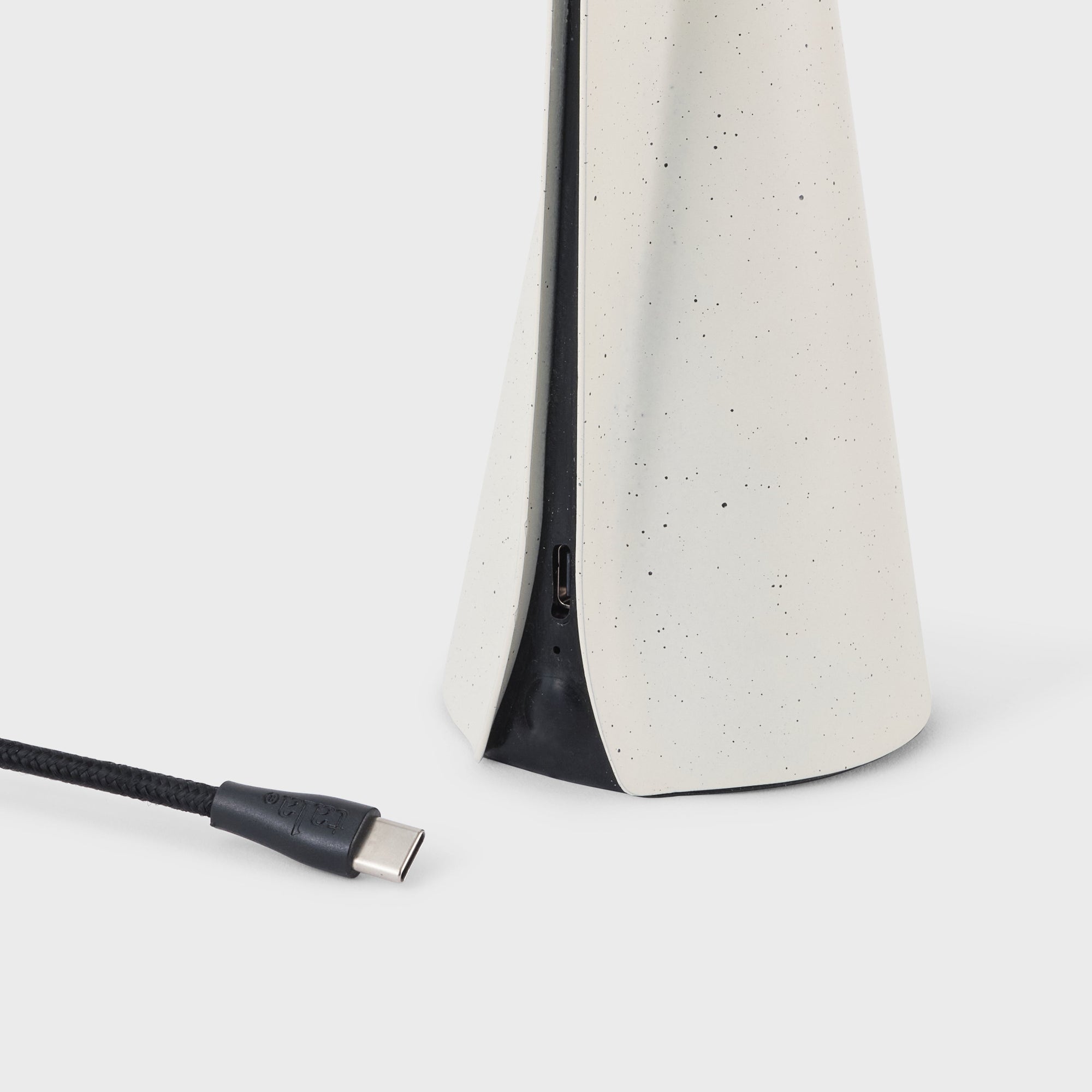Lamp base detail with USB cable on a white background