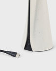 Lamp base detail with USB cable on a white background