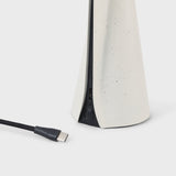 Lamp base detail with USB cable on a white background
