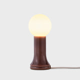 Table lamp with a brown base and white bulb on a light gray background