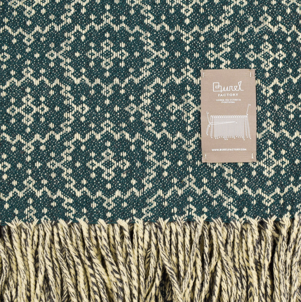 Woven fabric with a geometric pattern and brand label on a green background