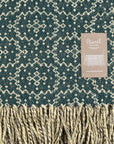 Woven fabric with a geometric pattern and brand label on a green background