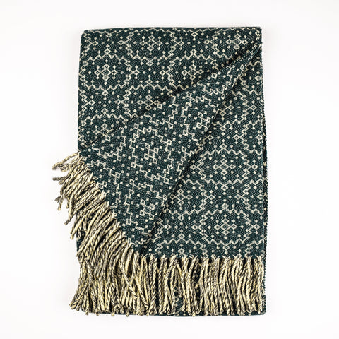 Woven blanket with geometric pattern and fringes on a white background