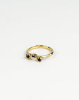 Gold ring with mixed dark  gemstones on a white background