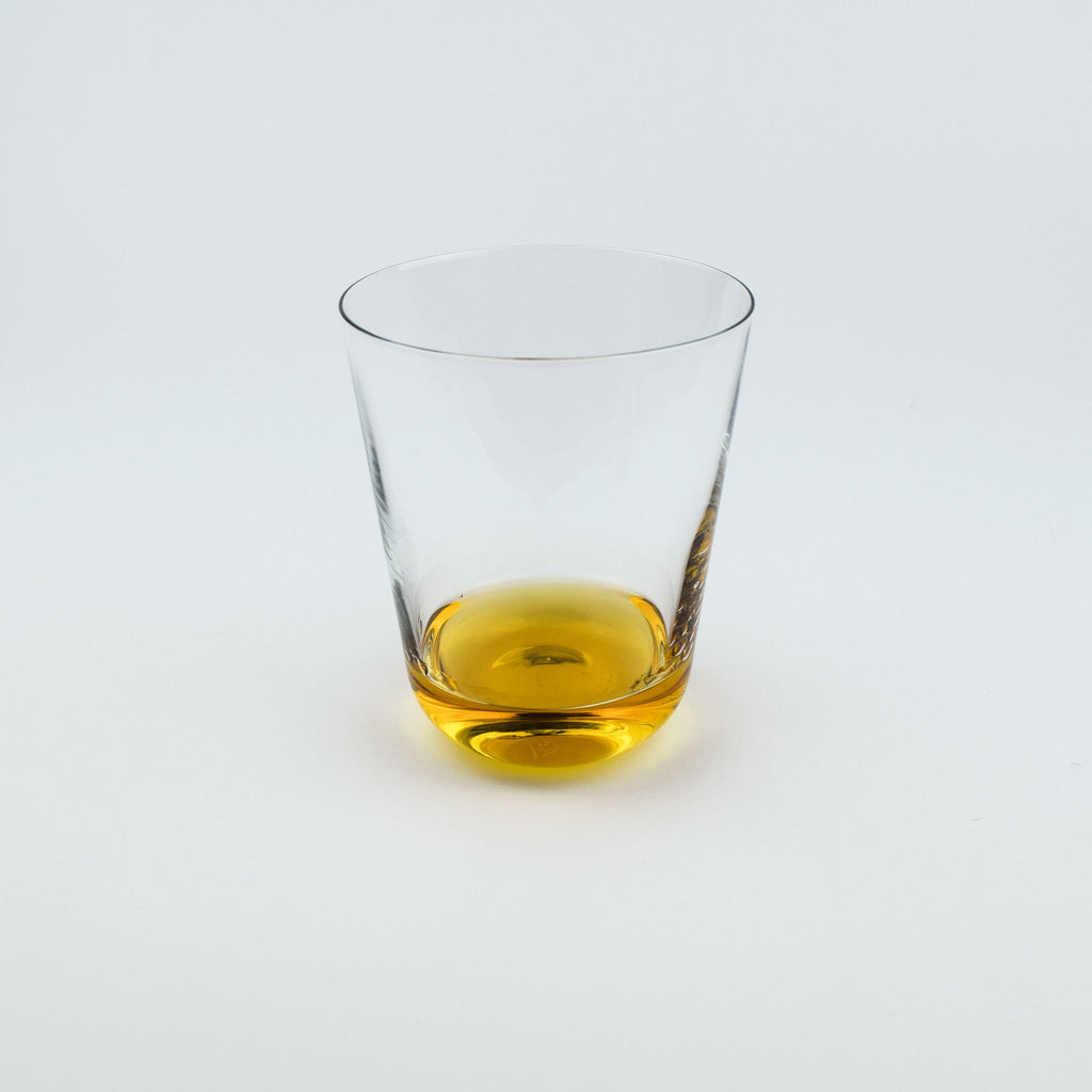 Clear glass with amber liquid on a white background