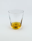 Clear glass with amber liquid on a white background