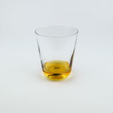 Clear glass with amber liquid on a white background
