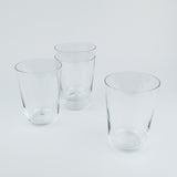 Four clear glass tumblers on a light gray background
