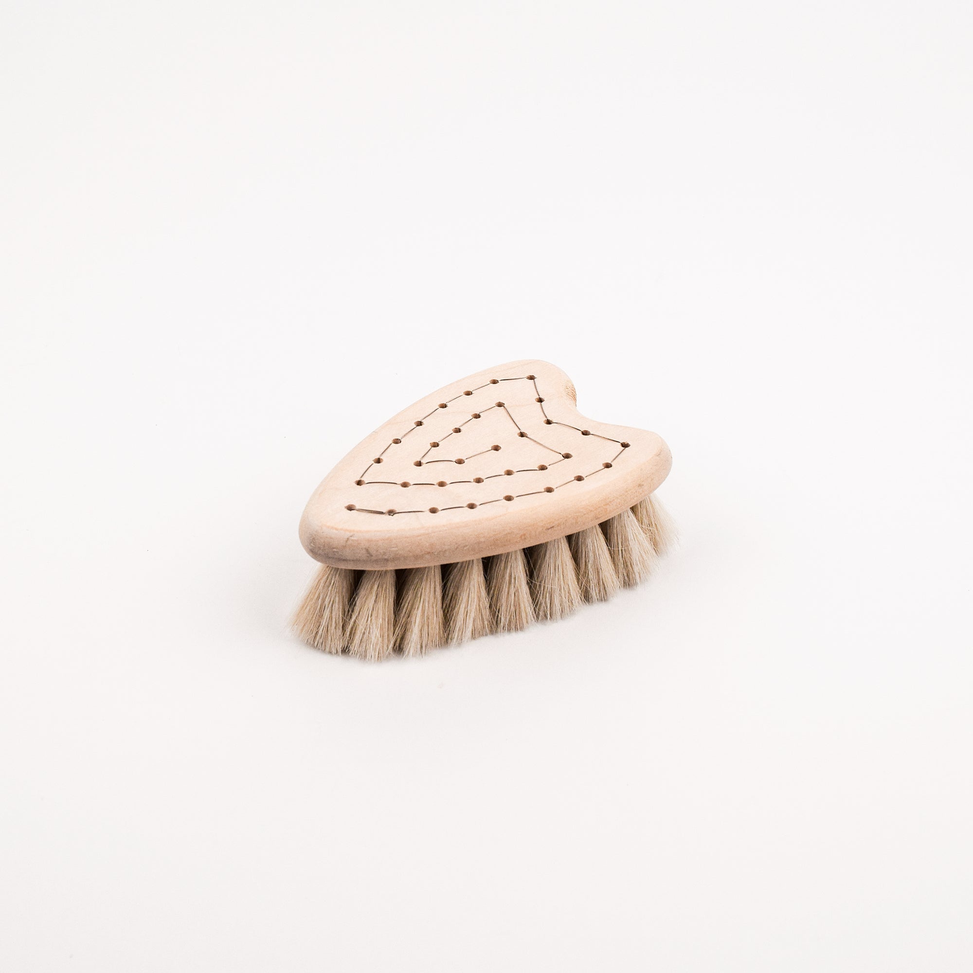 Heart shaped wooden brush with soft bristle head on a white background