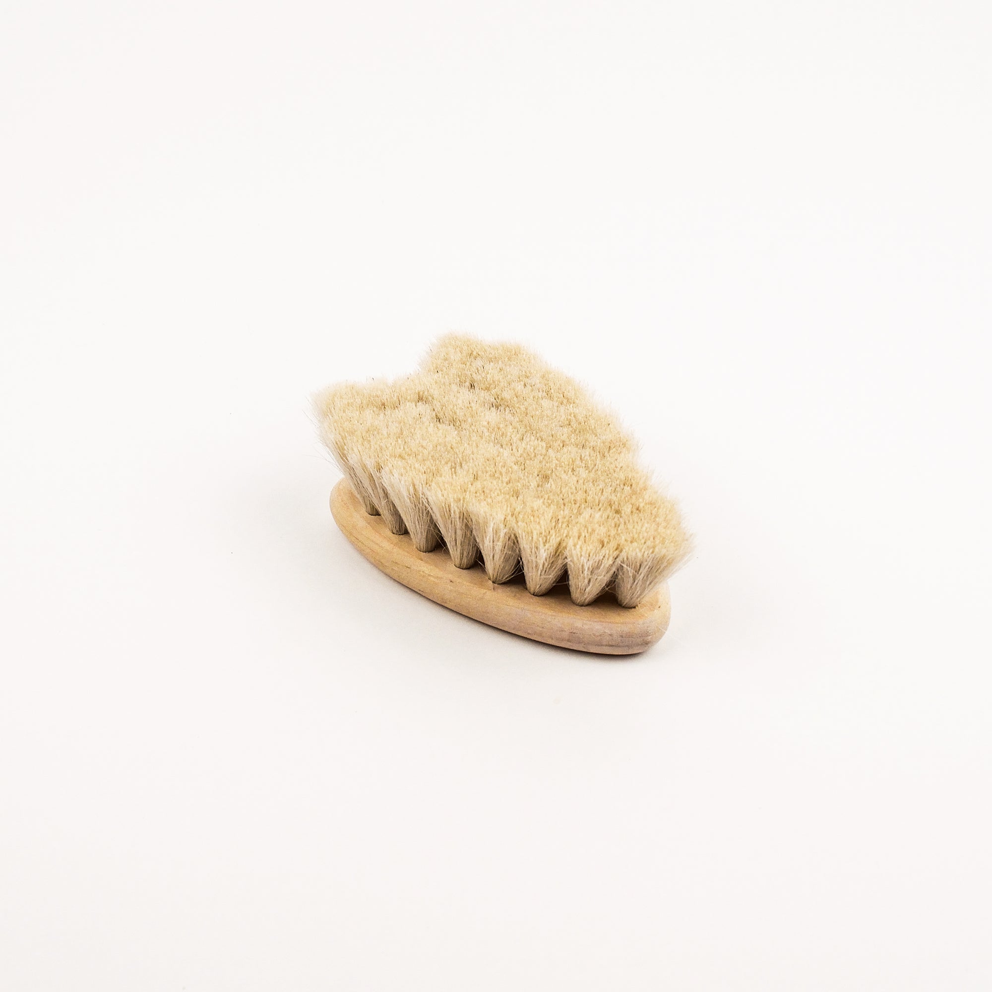Heart shaped baby hair brush with natural bristles on a white background