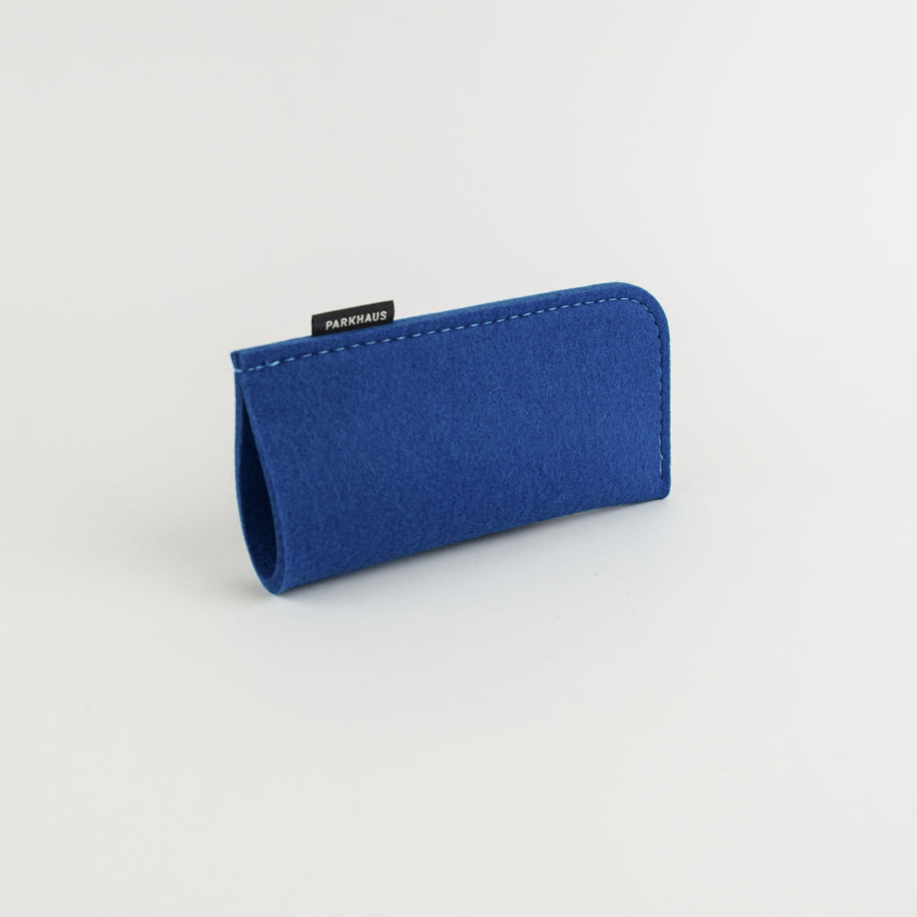 Blue felt eyeglass case with a brand label on a light gray background