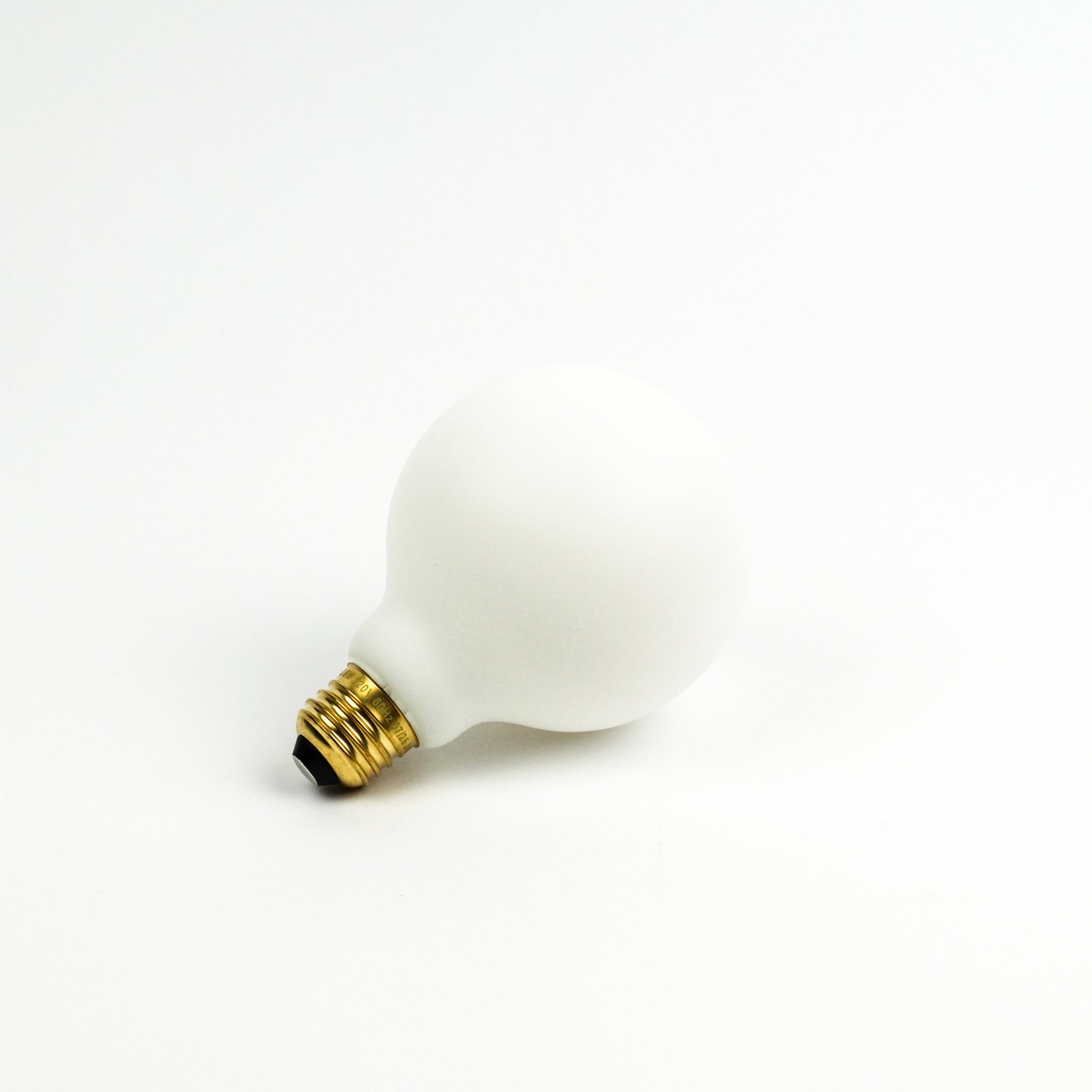 White light bulb with gold base on a white background