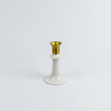 White candle holder with gold top on a white background