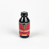 Bottle of Hibiscus Cardamom syrup with a red label on a white background