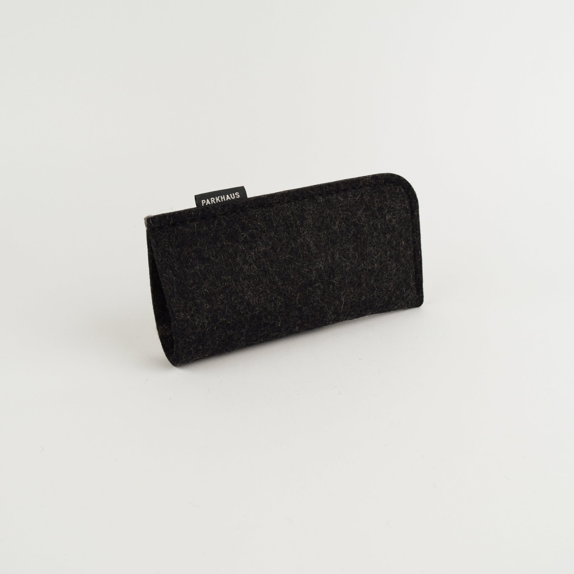 Black eyeglass case with 'PARKHAUS' label on a light gray background