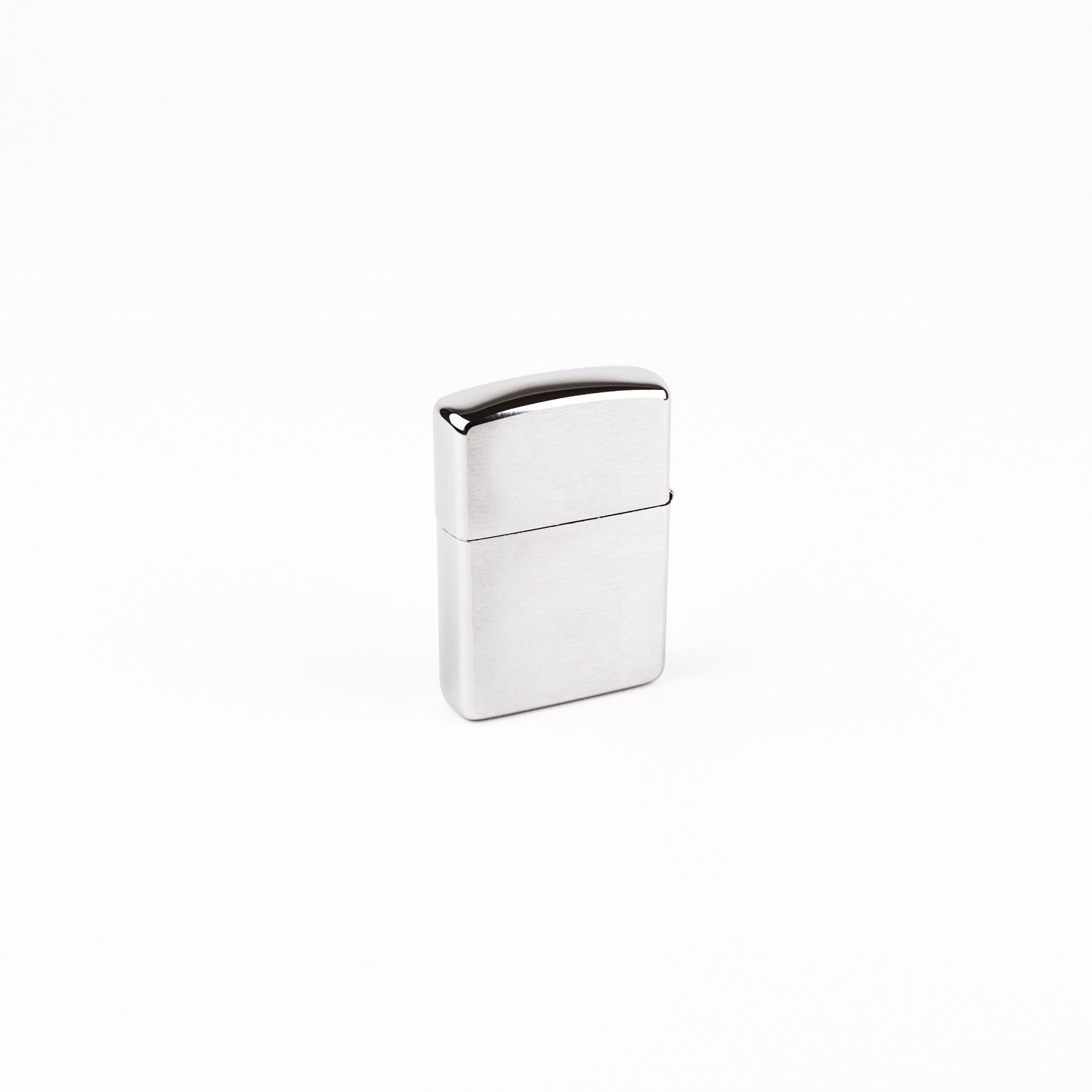 A classic rectangular metal lighter with a brushed and polished chrome finish, standing upright on a seamless white background.