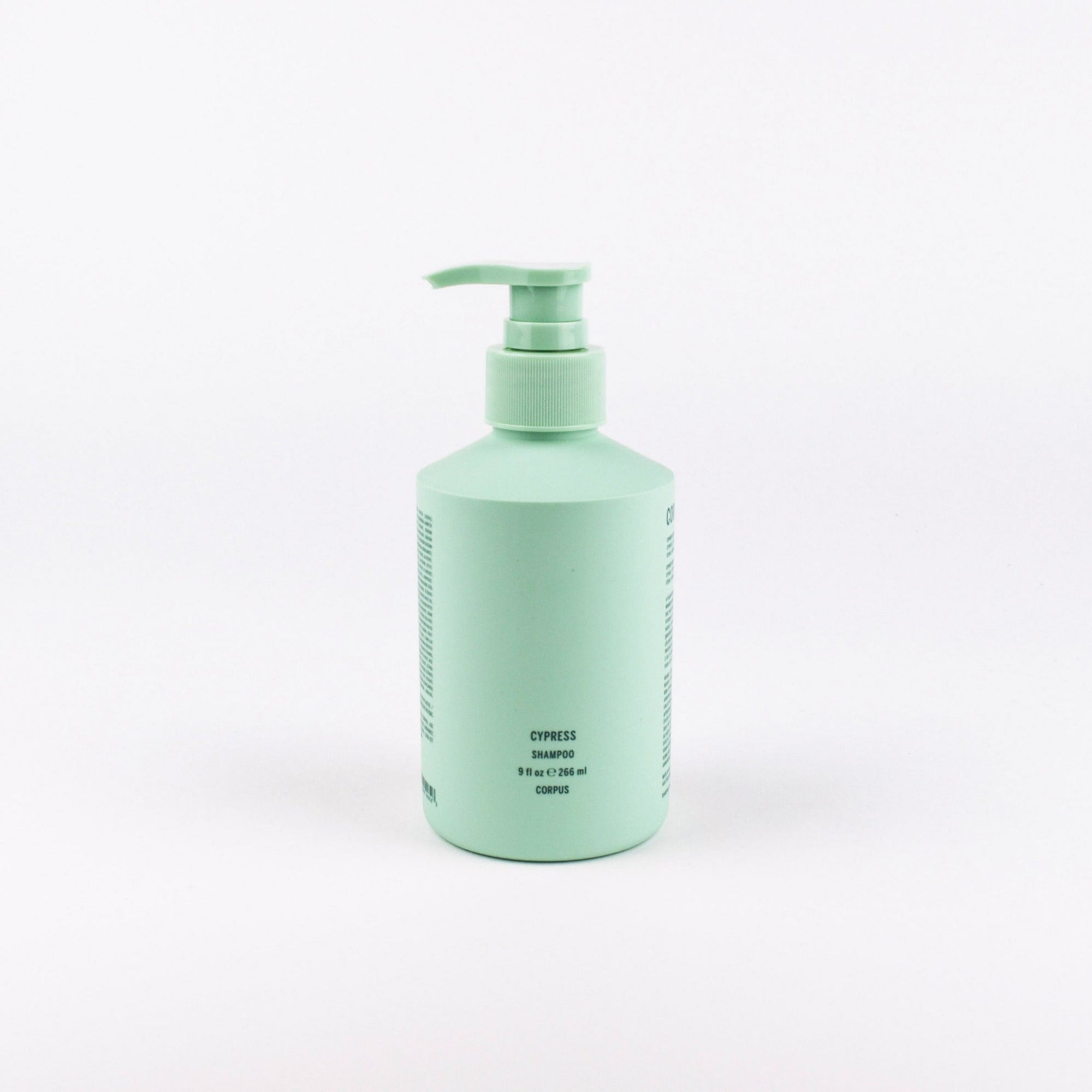 A mint green pump bottle of Cypress Shampoo on a clean white background.