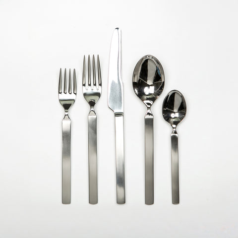 Set of silver cutlery including forks and knives on a white background