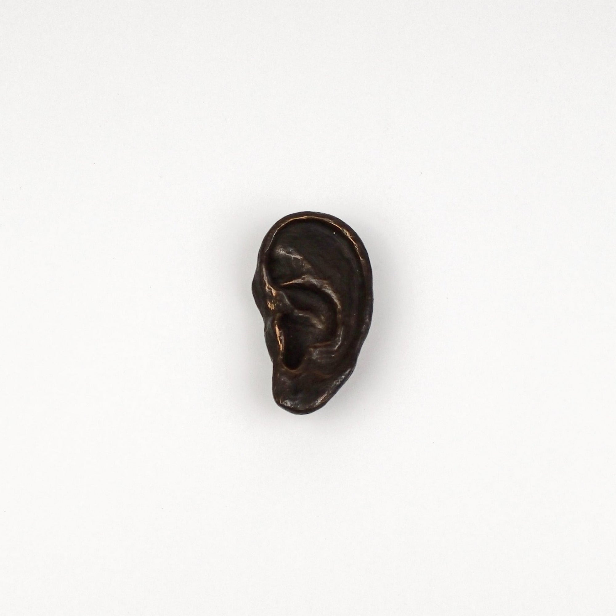 Bronze ear sculpture on a white background