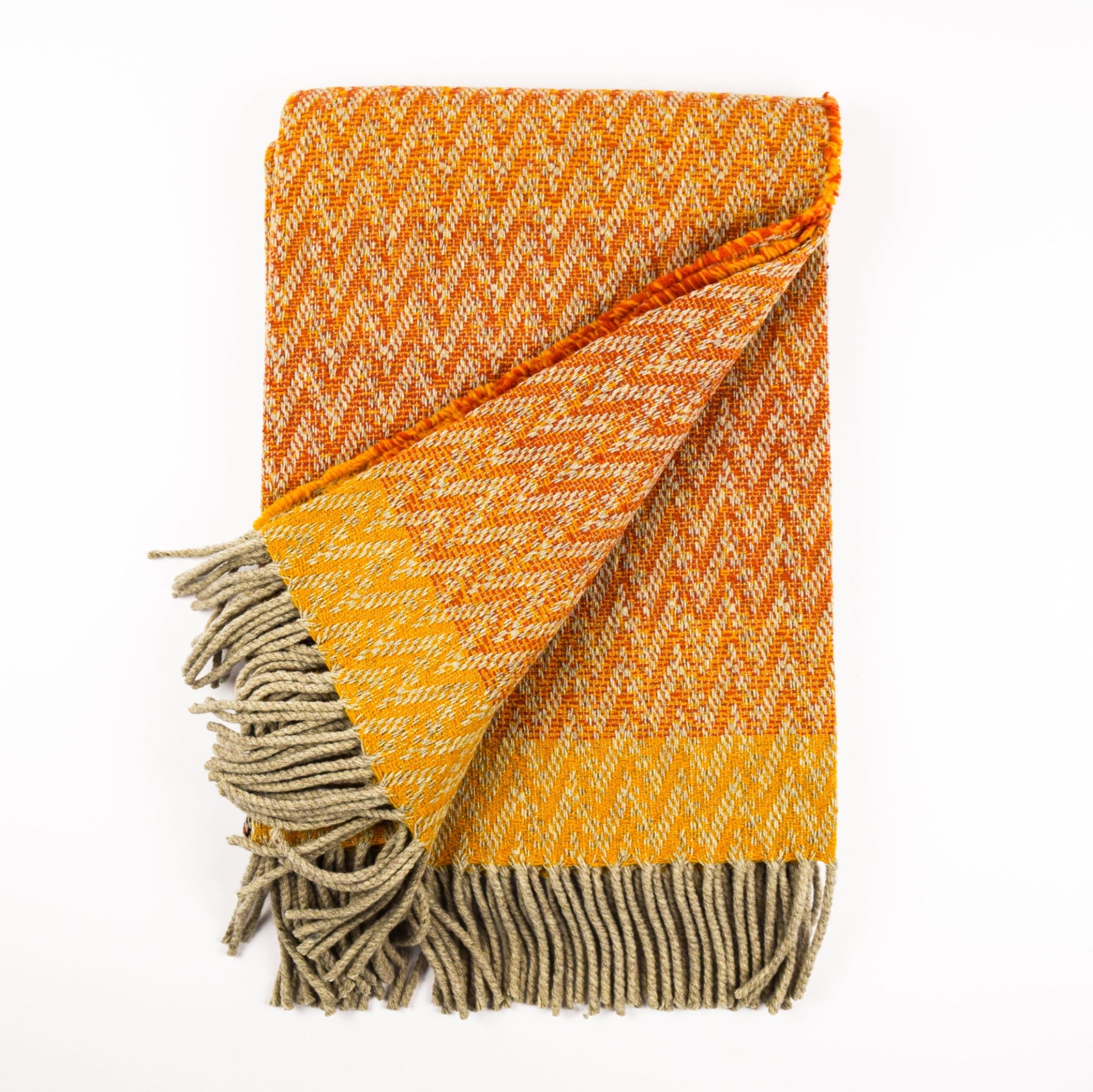 Orange and beige woven blanket with tassels on a white background