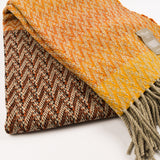 Folded woven blanket with a brand tag on a white background