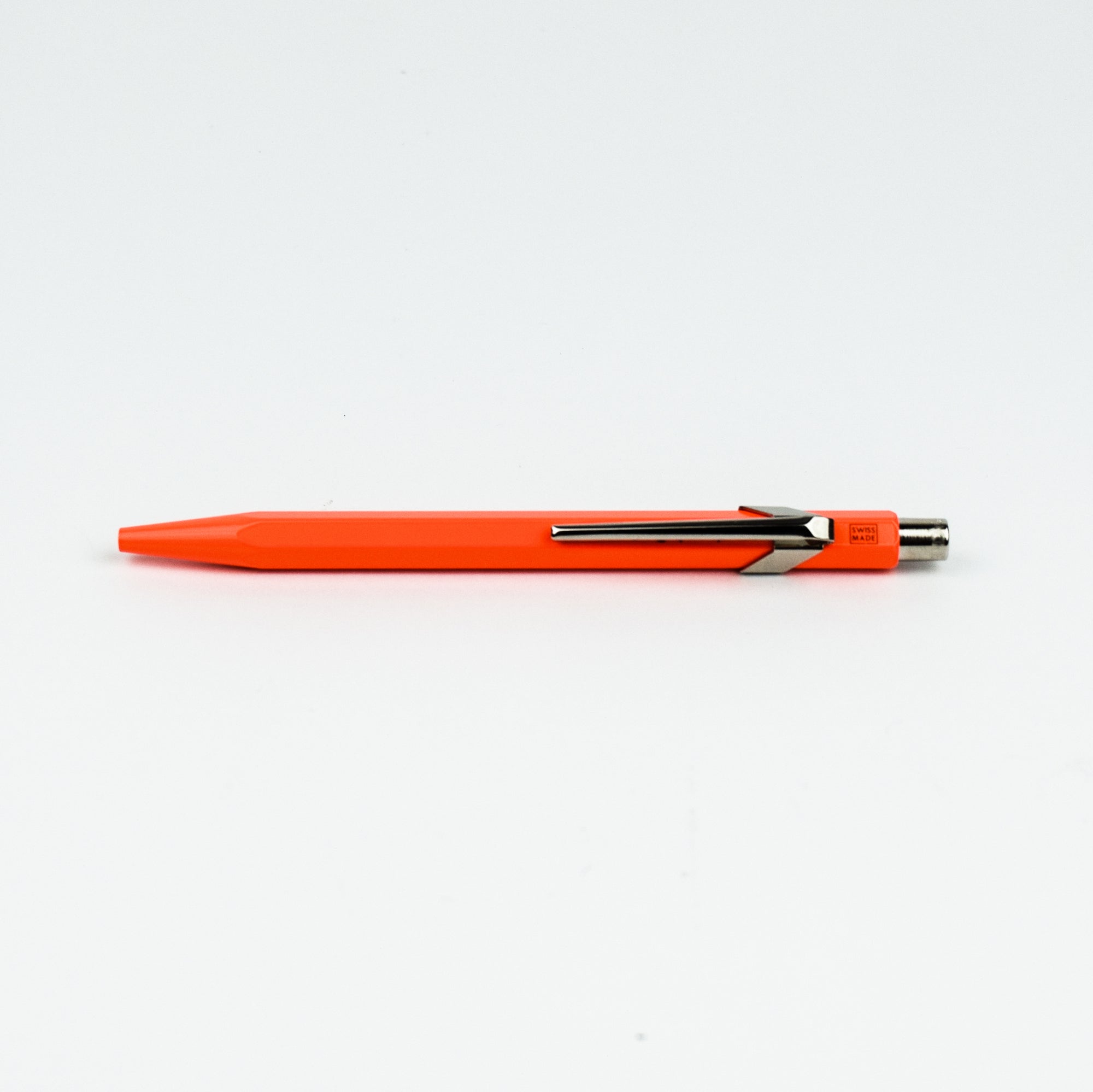 Orange pen with a metallic clip on a white background