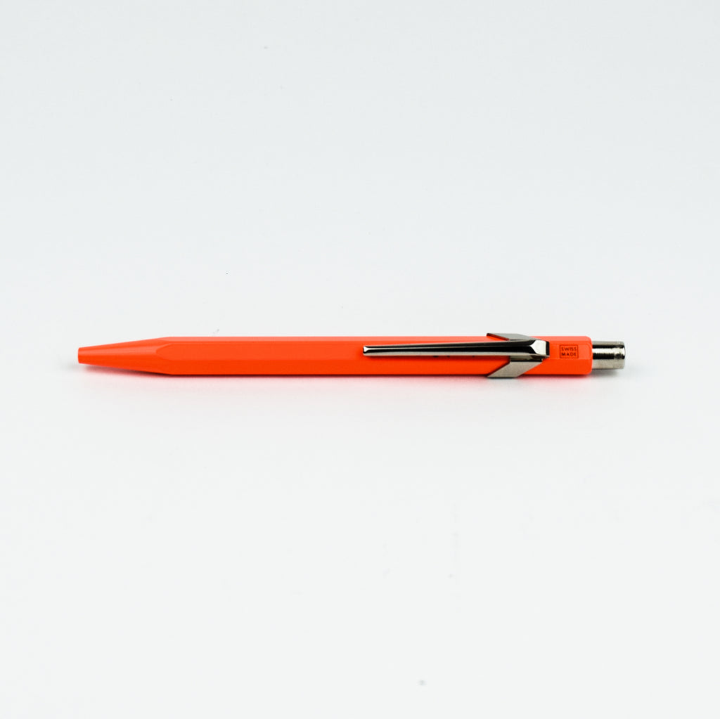 Orange pen with a metallic clip on a white background