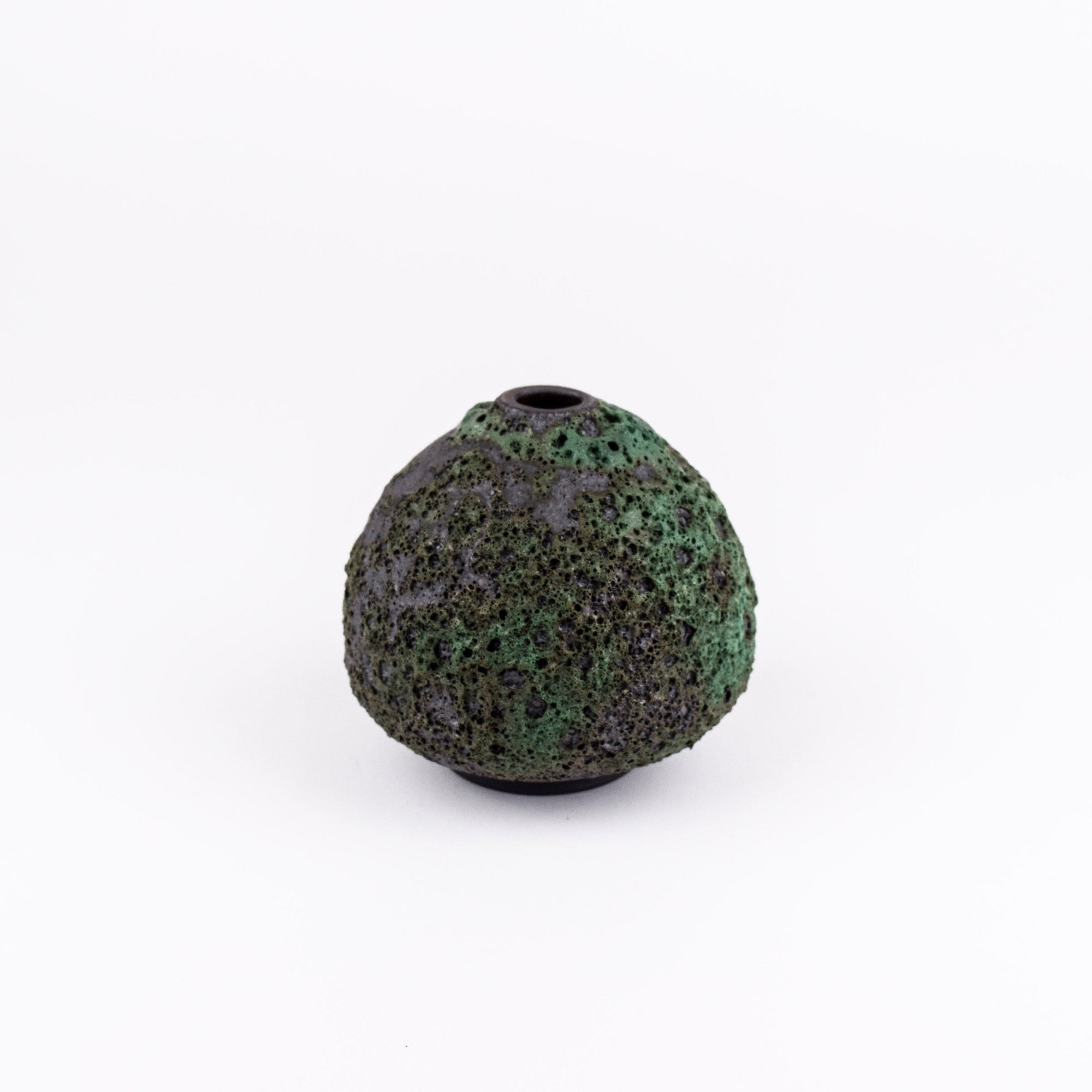 A small, rounded ceramic vase with a textured, speckled dark green and black glaze, featuring a narrow top opening, set against a plain white background.