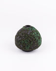 A small, rounded ceramic vase with a textured, speckled dark green and black glaze, featuring a narrow top opening, set against a plain white background.
