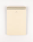 Beige notebook with a spiral binding on a white background