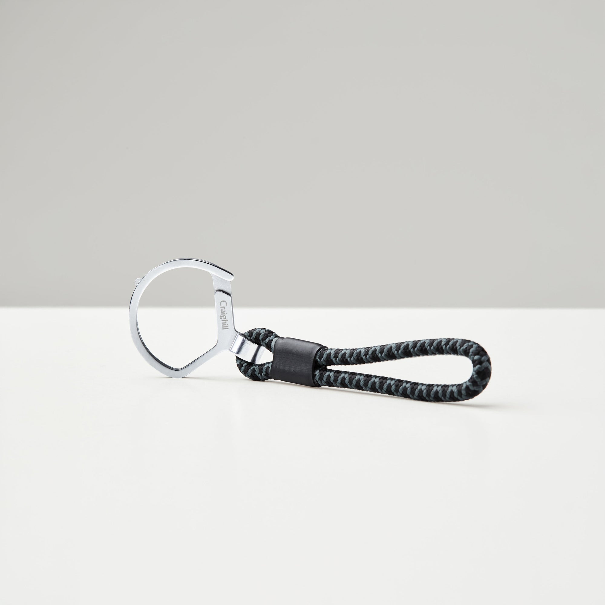 Keychain with braided black strap on a white background