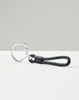 Keychain with braided black strap on a white background