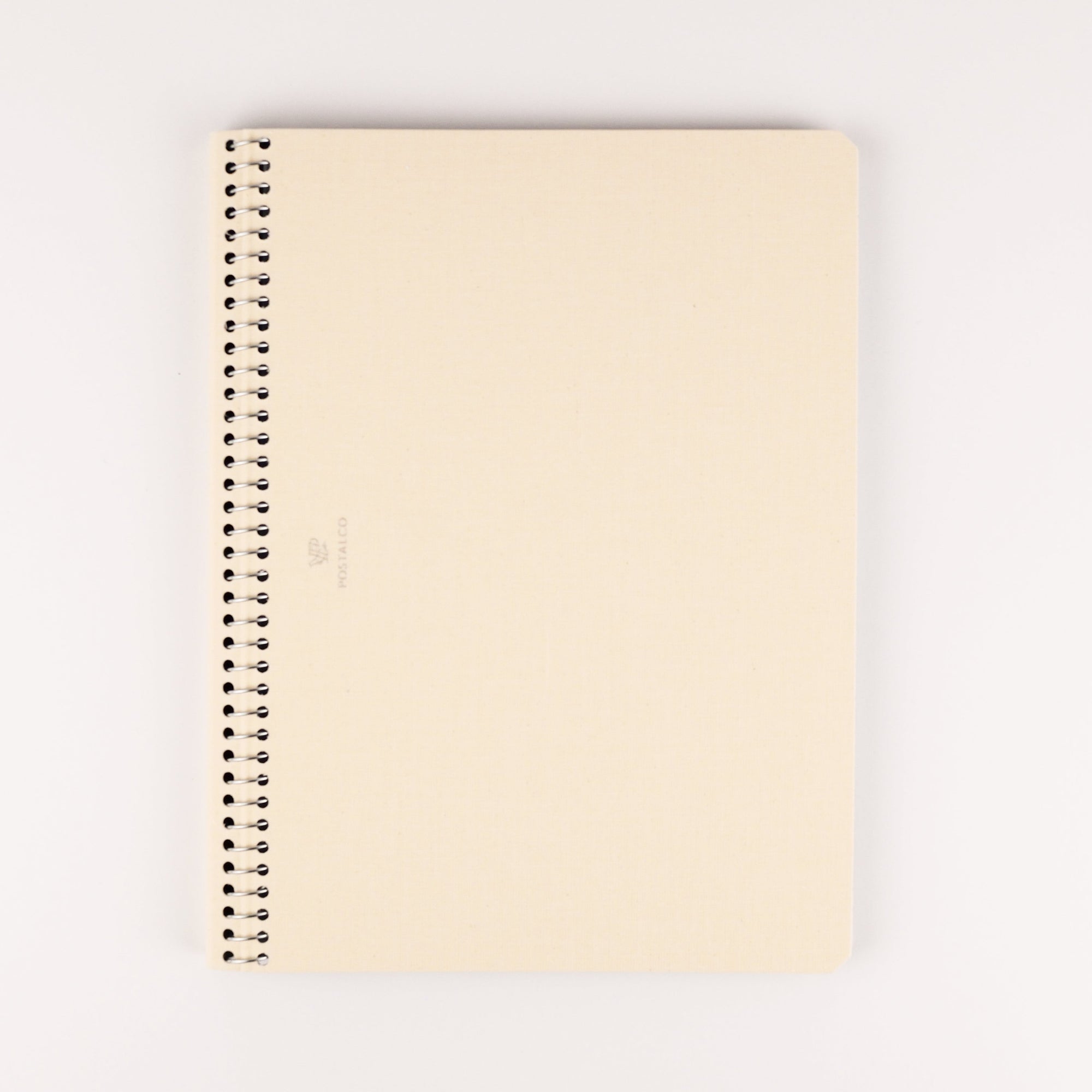 Ivory notebook with a spiral binding on a white background