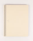 Ivory notebook with a spiral binding on a white background