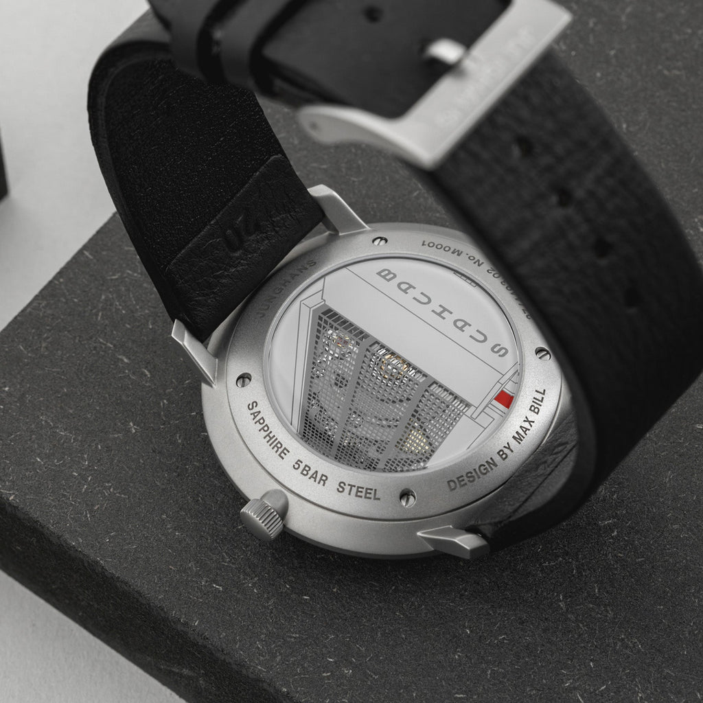 Close-up of a watch with a black strap on a dark surface