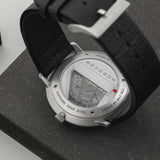 Close-up of a watch with a black strap on a dark surface