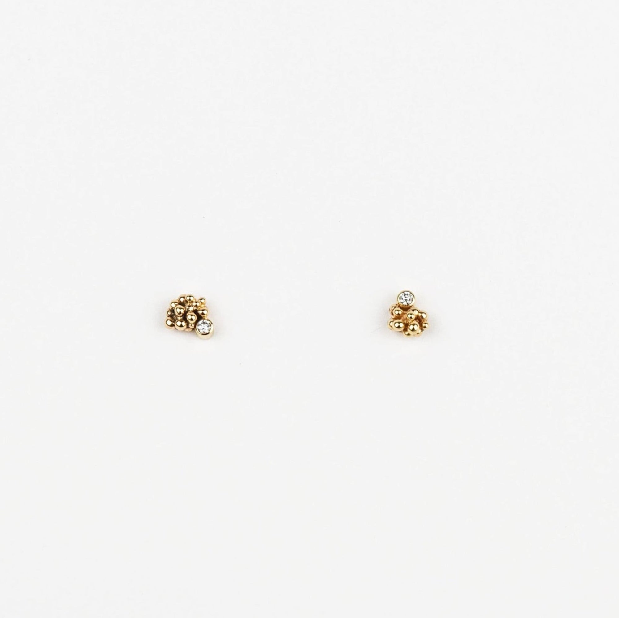 Pair of gold stud earrings on a white background