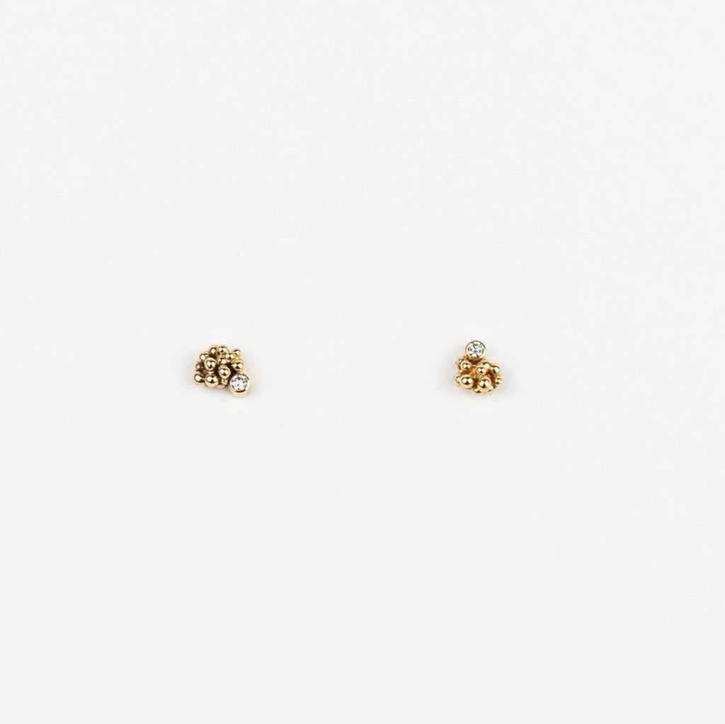 Pair of gold stud earrings on a white background