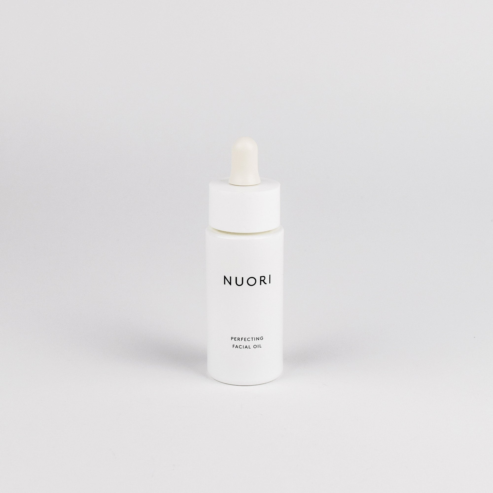 A white bottle of NUORI Perfecting Facial Oil with a white dropper cap, centered on a light gray background.