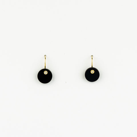 Pair of black earrings with gold hooks on a white background