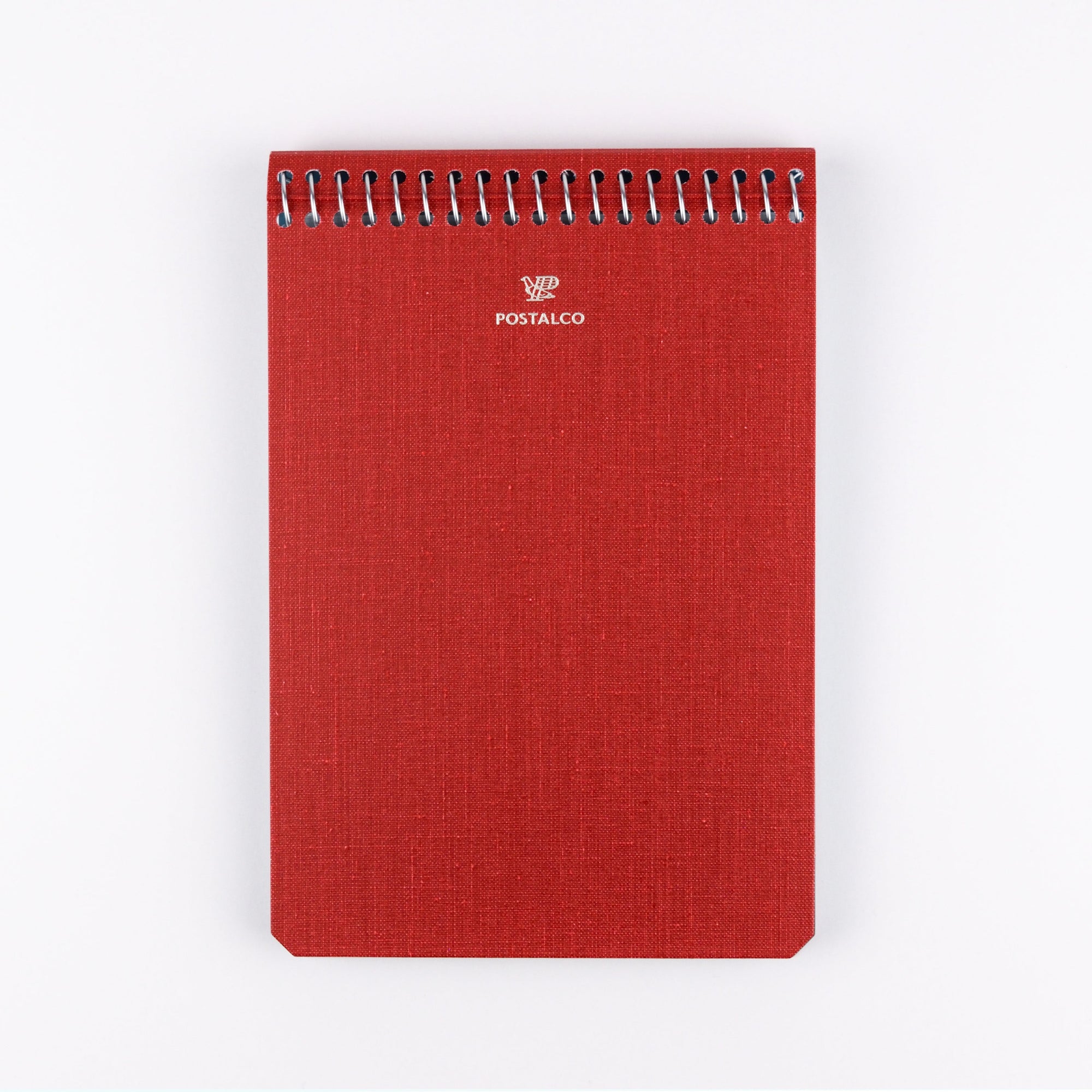 Red notebook with spiral binding on a white background