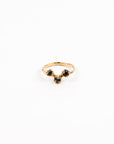 Gold ring with dark blue gemstones on a white background