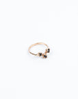 Gold ring with dark blue gemstones on a white background