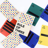 Colorful playing cards with geometric patterns and 'Rule of Three' text on a white background