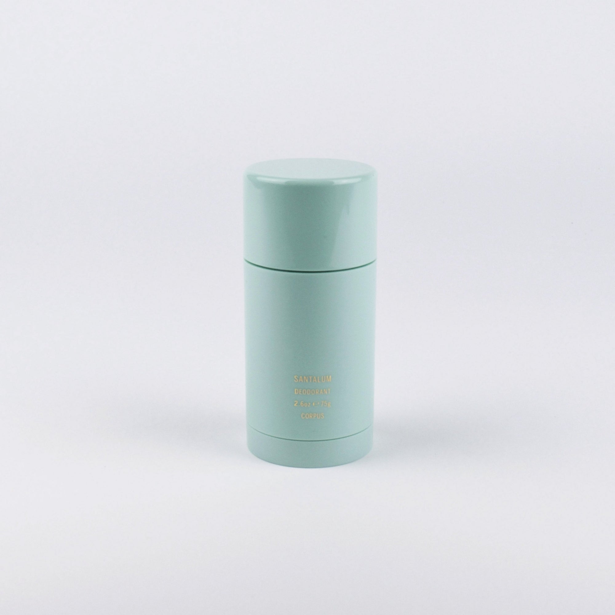 A mint green cylindrical deodorant container with a matching cap, featuring small gold text that reads 'DEODOR DEODOR TONK' on a clean white background.