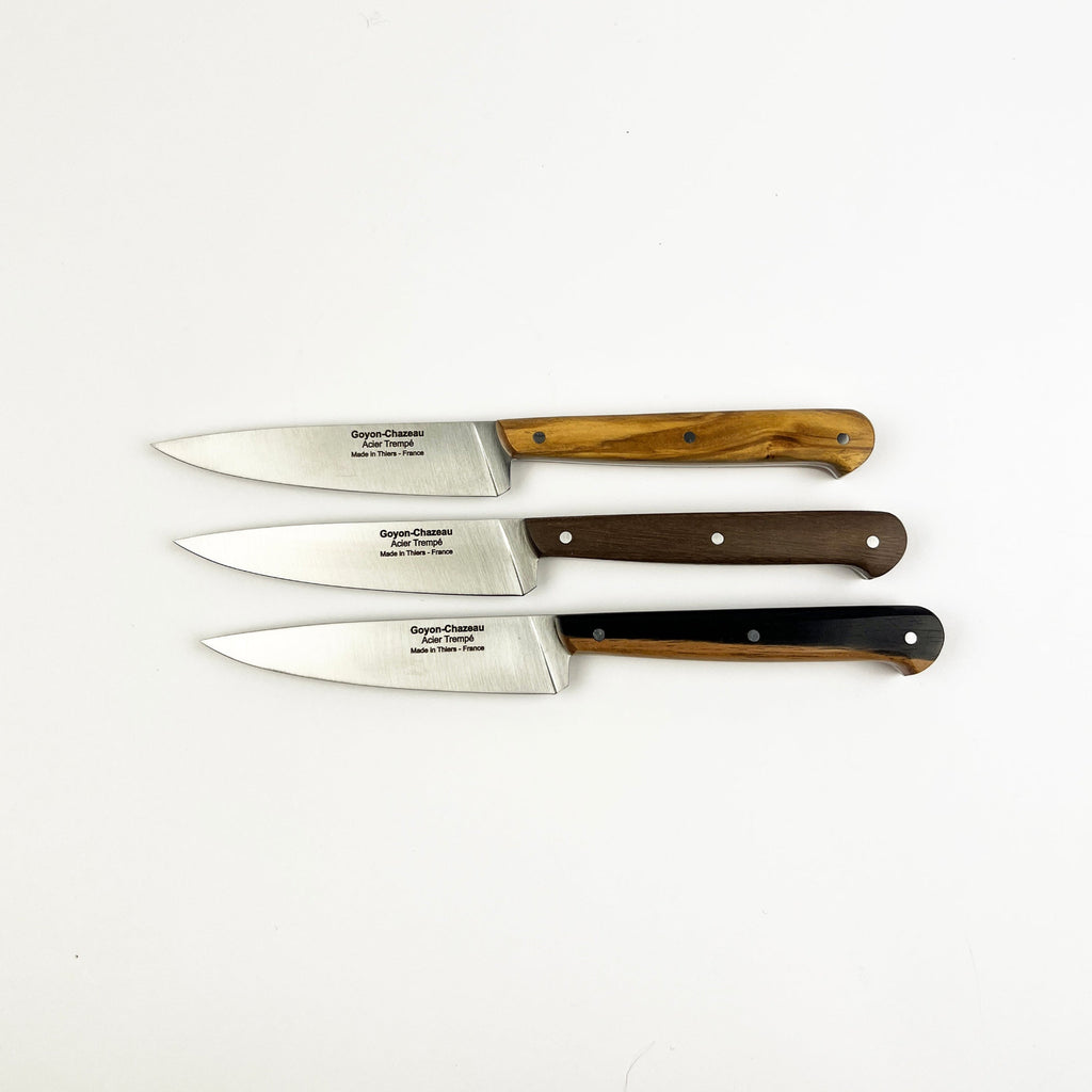 Four steak knives with wooden handles on a white background