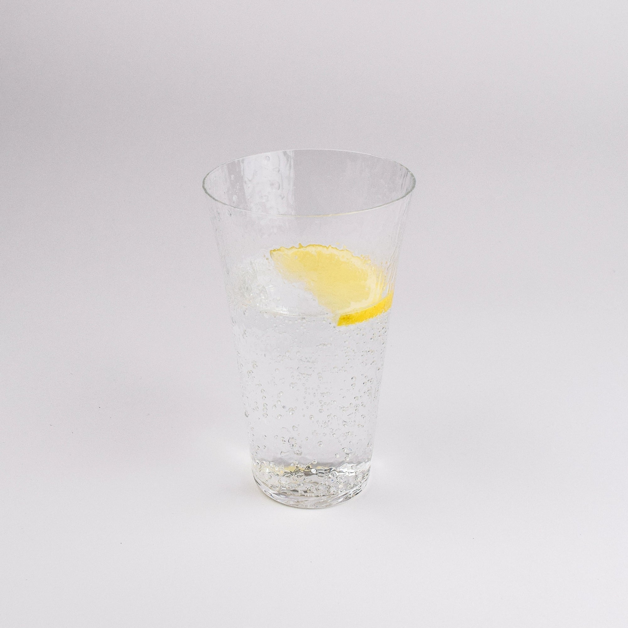 Clear glass with a lemon slice on a white background