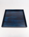 A square wooden tray with a dark blue and black watercolor-like textured finish, photographed from a top-down perspective on a clean white background.